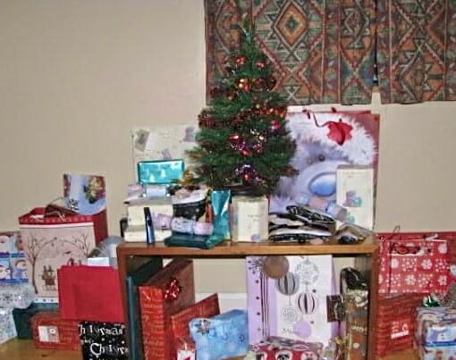 Small Christmas tree on a table with presents around on the table also